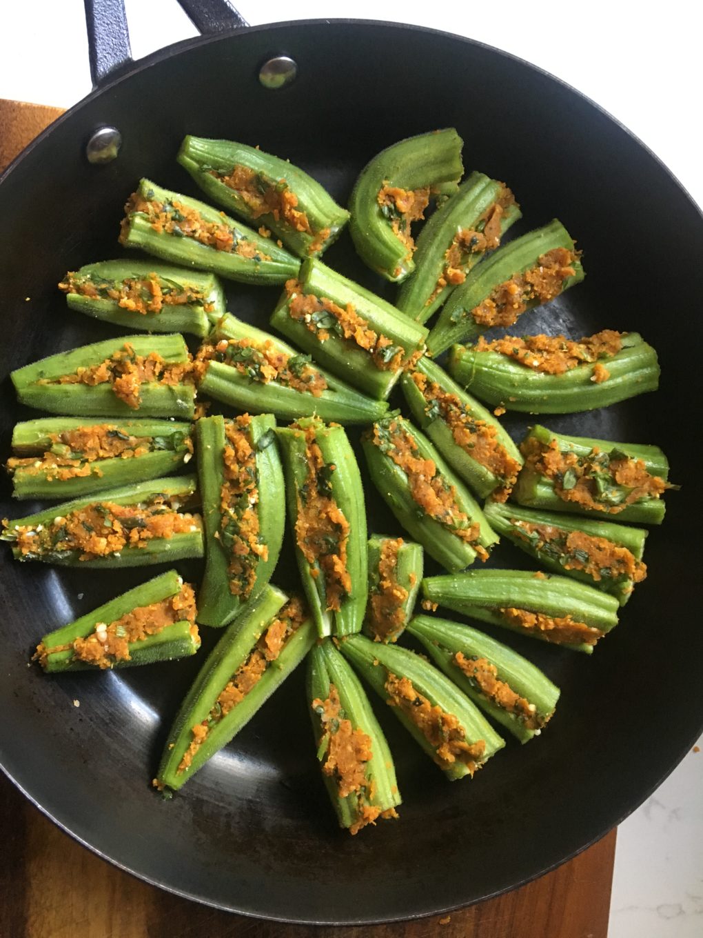 Stuff the okra and arrange it in the pan